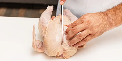 <b>Шаг 2: Отделяем грудку</b><br>Положите курицу тушку грудкой вверх. Сделайте глубокий продольный разрез вдоль&nbsp;грудной кости (киля). Важный момент: в&nbsp;основании грудки вы найдете небольшую V-образную косточку. Аккуратно надломите ее пальцами — это поможет мясу легче отделиться от&nbsp;костей. Аккуратно ведите нож вдоль&nbsp;рёбер, срезая филе с&nbsp;кости.