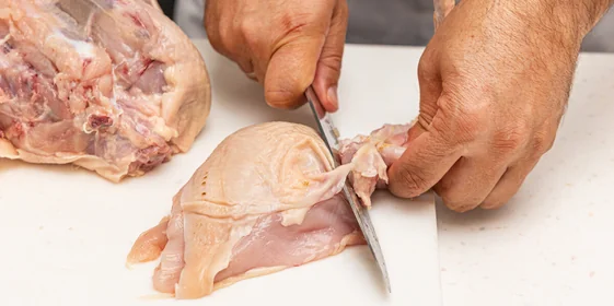 <b>Шаг 3: Отделяем крылья</b><br>Возьмите отделенную грудку. Найдите соединительный сустав между грудкой и крылом. Отведите крыло в сторону, натянув кожу, и аккуратно срежьте его по суставу.