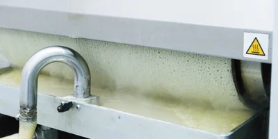 Замешенное тесто запускается в блинный аппарат. Внутри него барабан, разогретый до +237 градусов, накручивает на себя тесто с одной стороны