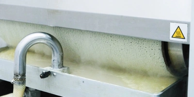 Замешенное тесто запускается в блинный аппарат. Внутри него барабан, разогретый до +237 градусов, накручивает на себя тесто с одной стороны