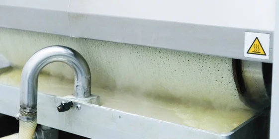 Замешенное тесто запускается в блинный аппарат. Внутри него барабан, разогретый до +237 градусов, накручивает на себя тесто с одной стороны