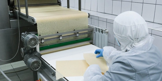 Барабан выпекает один большой пласт готового блина, который с помощью острых ножей делится на равные прямоугольники