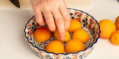 На дно формы для&nbsp;выпечки насыпьте сахар, положите абрикосы