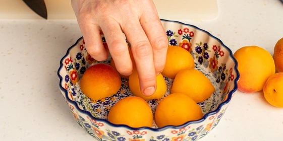 На дно формы для&nbsp;выпечки насыпьте сахар, положите абрикосы