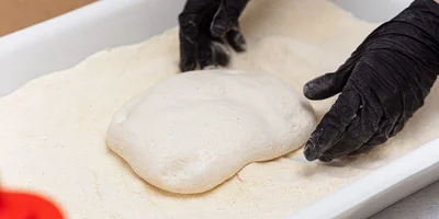 Тесто не раскатывают, а растягивают руками, придавая ему прямоугольную форму. Никакие скалки или автоматические тестораскатки не применяются — в ход идут только руки