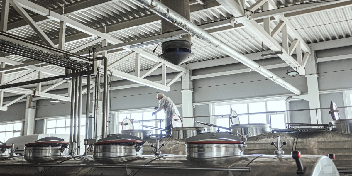 Водитель перемешивает молоко, а лаборант завода отбирает пробы и проводит анализ партии