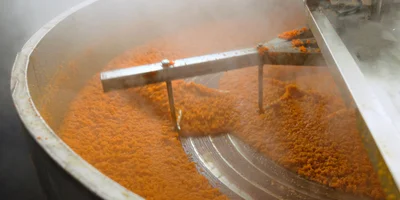 Лук и морковь измельчают и на больших промышленных сковородах пассеруют отдельно друг от друга