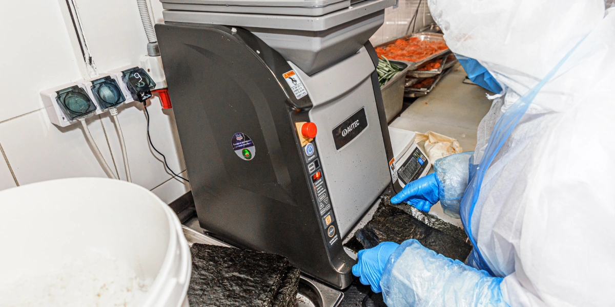 Суши-робот формирует пласт риса определённого веса, к&nbsp;которому сотрудник уже приклеивает лист нори 