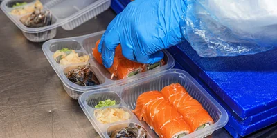 Роллы выкладывают в упаковку и передают на автоматизированную линию вакуумного упаковщика, который замещает воздух в лотке на газомодифицированную среду