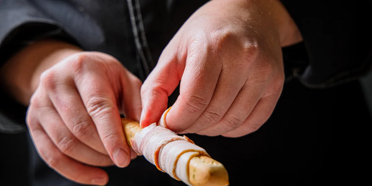 Неподатливый бекон можно обмотать вокруг палочки гриссини