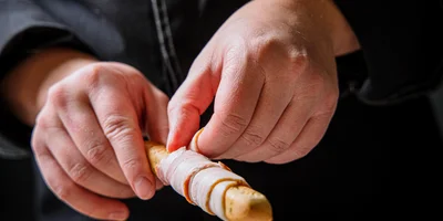 Неподатливый бекон можно обмотать вокруг палочки гриссини