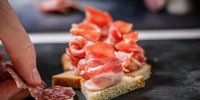 Сверните из мясного деликатеса розочку и подайте на кусочке хлеба