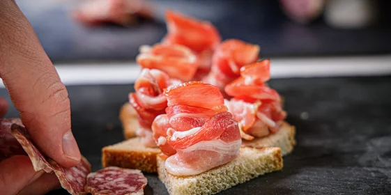 Сверните из мясного деликатеса розочку и подайте на кусочке хлеба