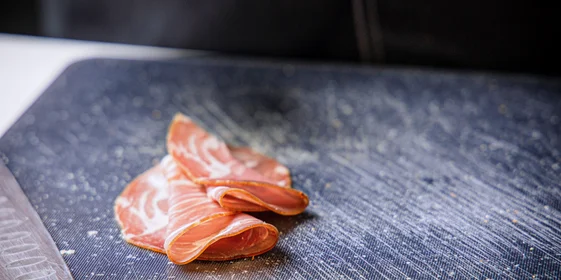 Выдержанную сыровяленую шейку можно оригинально подать, сложив волнами