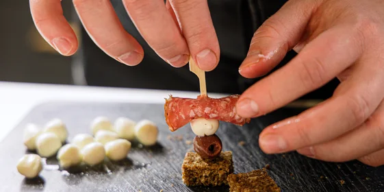 Сверните ломтики колбасы, хлеб нарежьте одинаковыми кусочками. Последовательно наколите на шпажку колбасу, сыр, оливку и хлеб