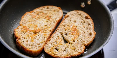 Подрумяньте хлеб с двух сторон на горячей сковороде, добавив ароматное оливковое масло