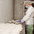 Тесто выкладывают на разделочный стол, где с помощью пекарского скребка придают ему круглую форму и дают отдохнуть ещё 30 минут