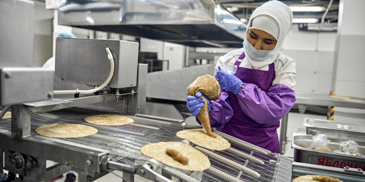 Начинку добавляют вручную. Сотрудницы на заводе делают это на глаз — получается точнее, чем если бы этим занимался дозатор