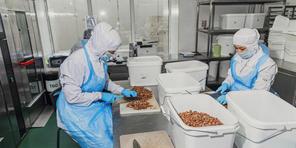 Орехи нарезают, запекают в печах, дают им остыть и только на фасовке добавляют в мороженое