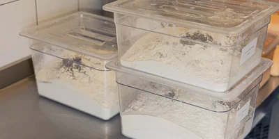 Контейнеры с сахаром, мукой и молотыми стручками ванили, которые просеяли перед смешиванием