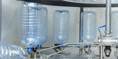 По конвейеру бутылки поступают на мойку, розлив и укупорку колпачком