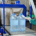 Бутылки с водой поступают в группиратор, который формирует упаковку и подаёт её в термоусадочную печь
