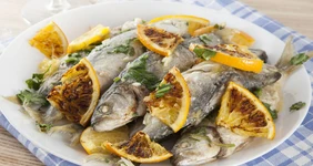 Жареный луфарь с апельсинами и чесноком